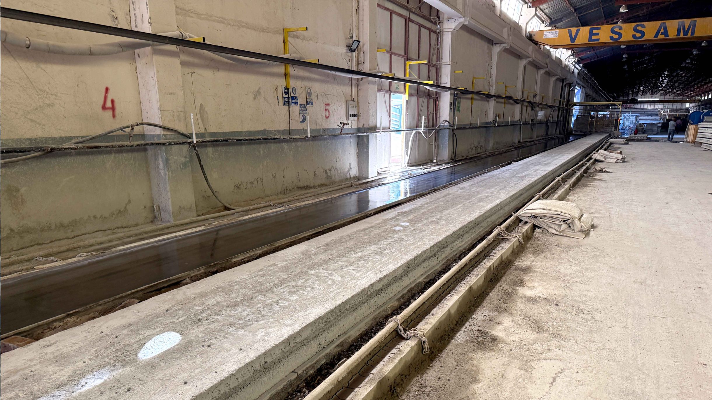 Banc de production pour la fabrication de dalles alvéolées chez Vessam Prefabrik avec surface préparée.